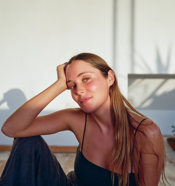 A woman sitting with her hand holding her head up